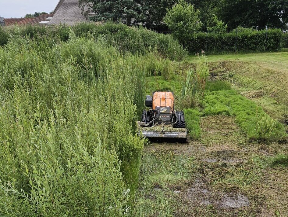 Mähraupe im Regenrückhaltebecken Mulchen von Regenwasser Rückhaltebecken